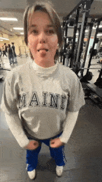a young woman is sticking her tongue out in a gym .