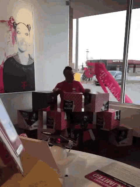 a man in a red shirt stands in front of a t mobile store