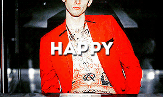a man in a red jacket is sitting in front of a sign that says " happy "