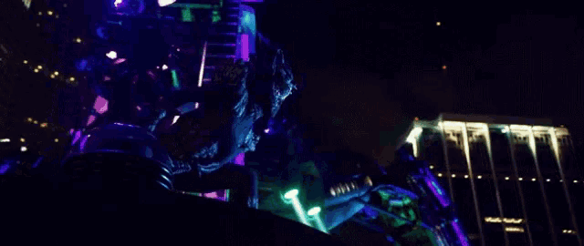 a person standing in front of a building with purple lights