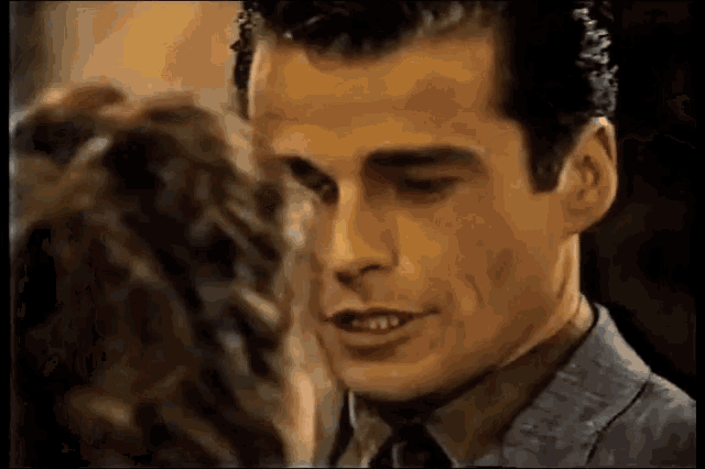 a man in a suit and tie is looking at a woman in a room .