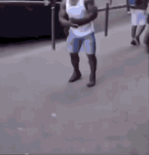 a man in a white shirt and blue shorts is crawling on the ground .
