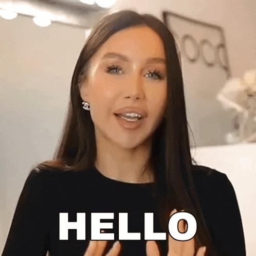 a woman in a black shirt is saying hello with her hands