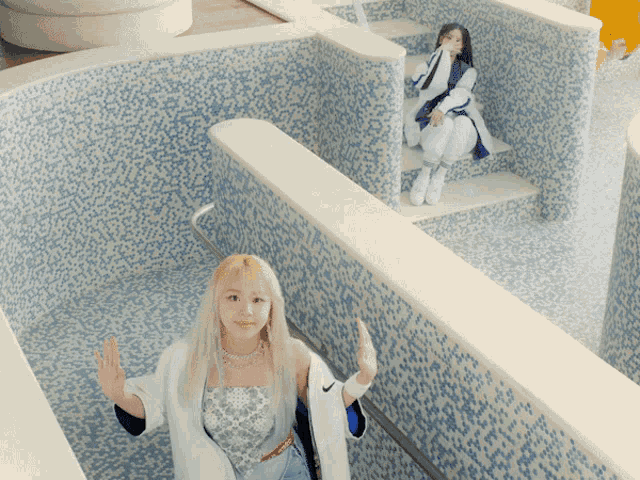 a woman in a white nike jacket is walking down stairs next to another woman