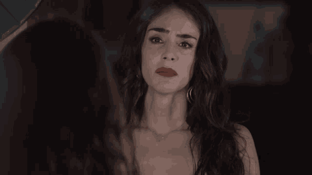 a woman with red lipstick is looking at herself in a mirror