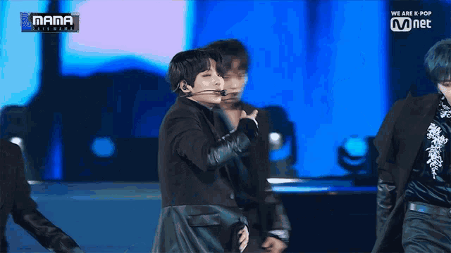 a group of men are performing on a stage in front of a sign that says mama on it