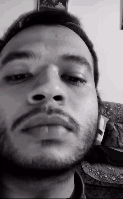 a black and white photo of a man 's face with a beard