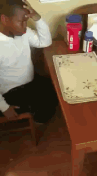 a man sitting at a table with a bottle of tylenol in front of him