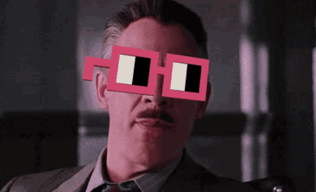 a man wearing a suit and tie has a pair of pink glasses on his face