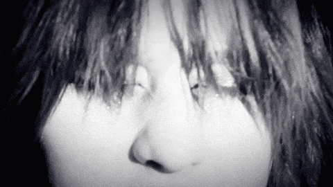 a black and white photo of a woman 's face with tears running down her face .