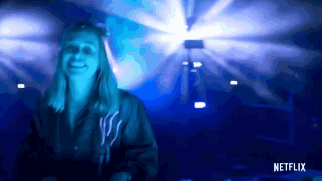 a woman in a dark room with a netflix logo on the bottom