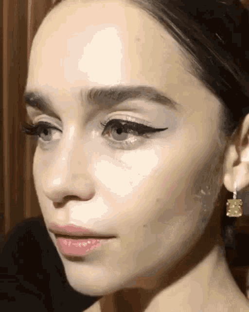 a close up of a woman 's face with earrings on