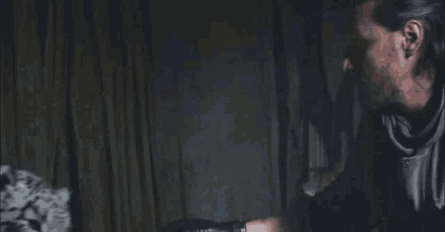 a man and a leopard are looking at each other in the dark