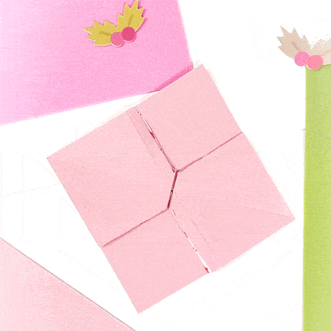 a pink origami bird with leaves on it is sitting on a table