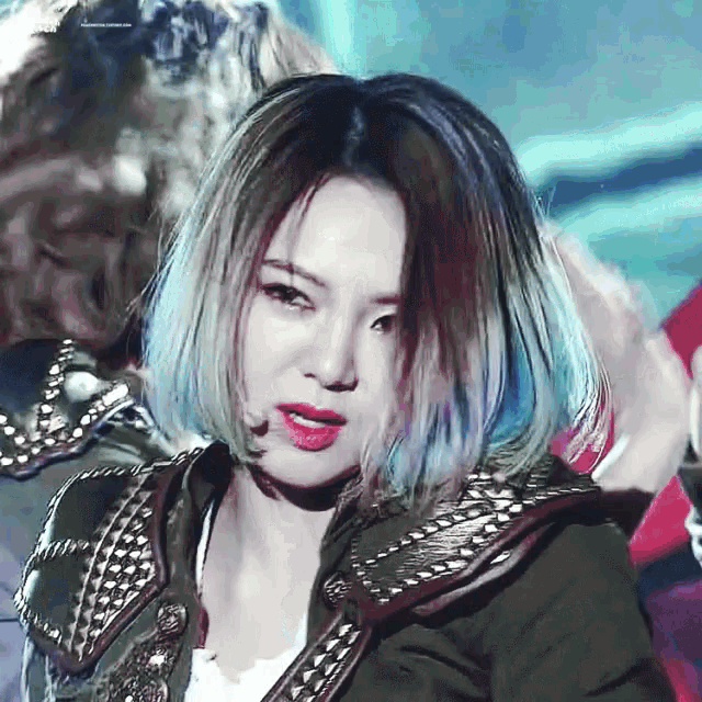 a close up of a woman 's face with blue and red hair