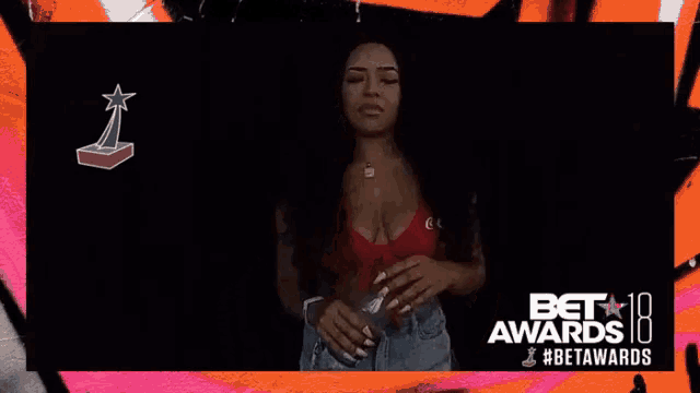 a woman in a red top is holding a bottle of water in front of the bet awards logo