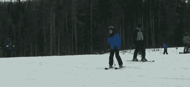 a person skiing down a snow covered slope with a sign in the background that says ' a-peak '