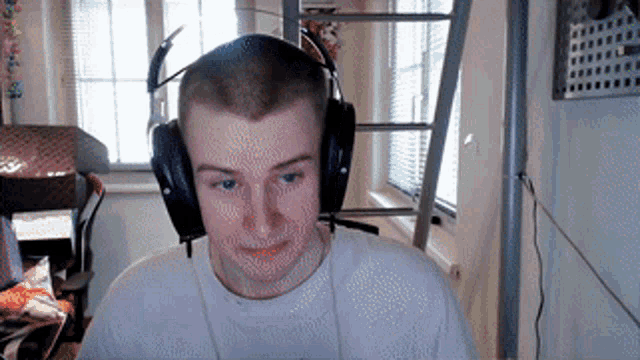 a man wearing headphones is sitting in front of a computer screen