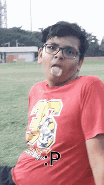 a young boy wearing a red shirt with the number 35 on it