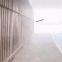 a plane is flying through a hallway with a wooden fence .