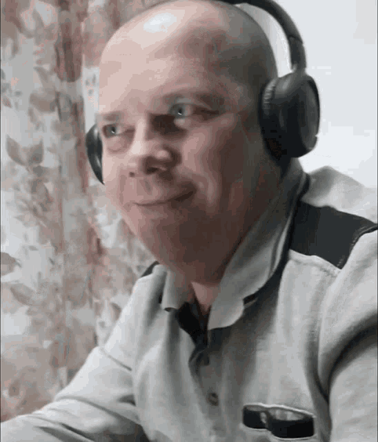 a man wearing headphones looks at the camera and smiles
