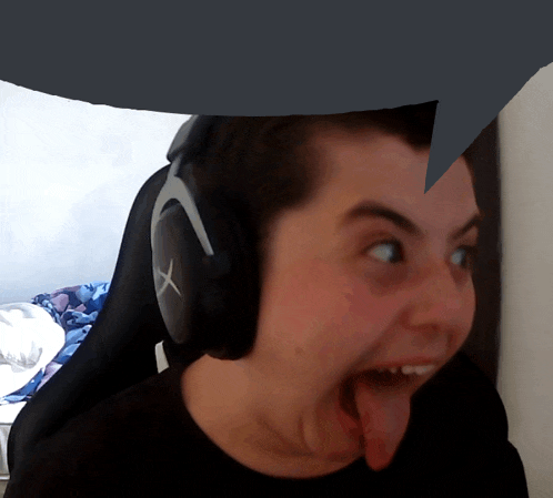 a man wearing headphones with an x on them sticks out his tongue