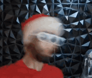 a blurry picture of a man wearing a red hat and glasses .