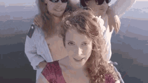 a group of people are standing next to each other on a boat in the water .
