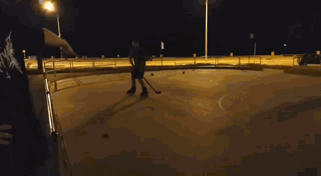 a person holding a hockey stick in a dark street