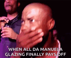 a bald man is covering his mouth with his hand while holding a glass of wine .