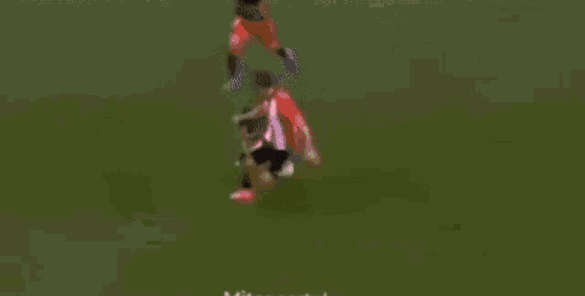 a soccer player in a red and white uniform is kicking a soccer ball .
