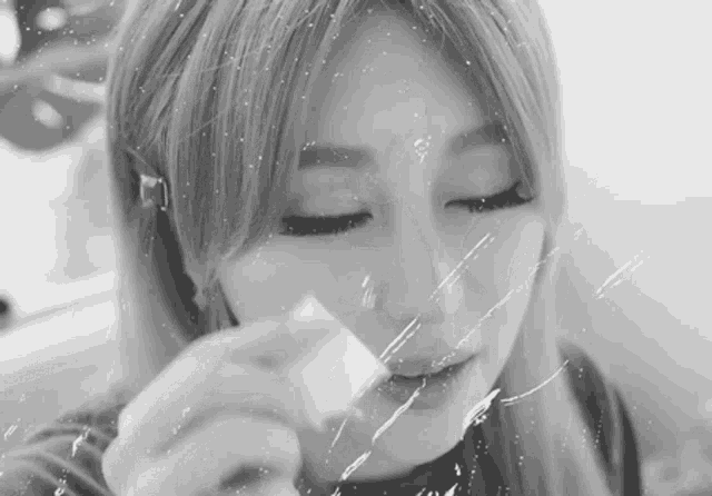 a black and white photo of a woman holding a piece of plastic