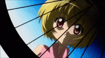 a girl looking through a bicycle wheel with a blue sky in the background