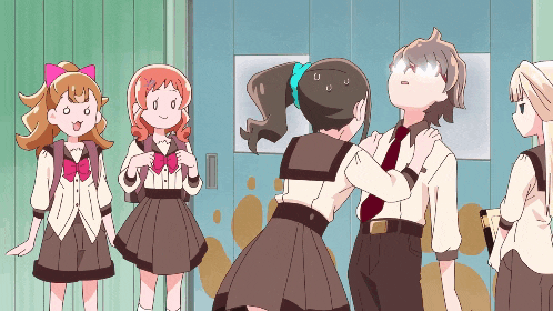 a group of girls are standing in a hallway and one girl has a pink bow in her hair