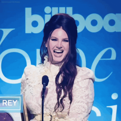 a woman laughs in front of a sign that says billboard one