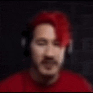 a blurry picture of a man with red hair and headphones on .