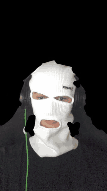 a man wearing a white ski mask and headphones with the word oreal on it