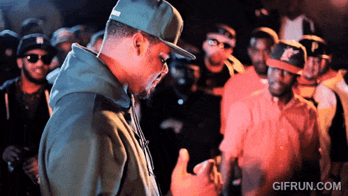 a gif from gifrun.com shows a man wearing a hat and a hoodie
