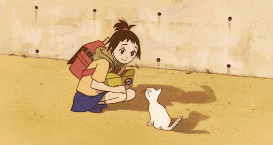 a person is feeding a cat a fish shaped cookie .