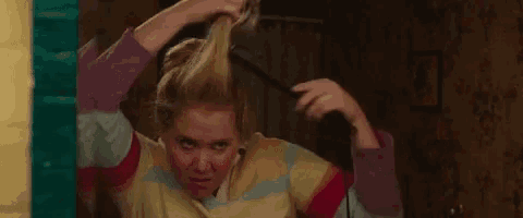 a woman is holding a hair straightener in her hand .