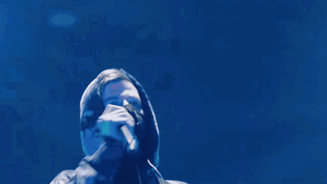 a person holding a microphone with the words come on now on the bottom right