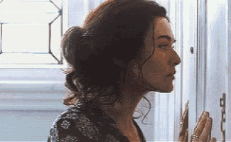 a woman is standing in front of a door and looking at it .