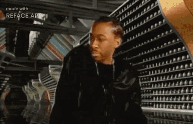 a man in a black jacket is standing in front of a row of shelves in a store .