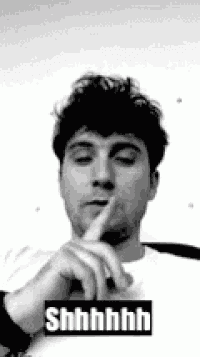 a man is making a shhh gesture with his finger to his mouth .