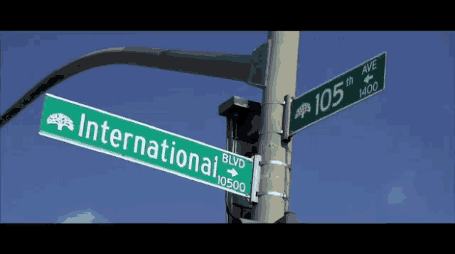 a green street sign for international blvd. is on a pole