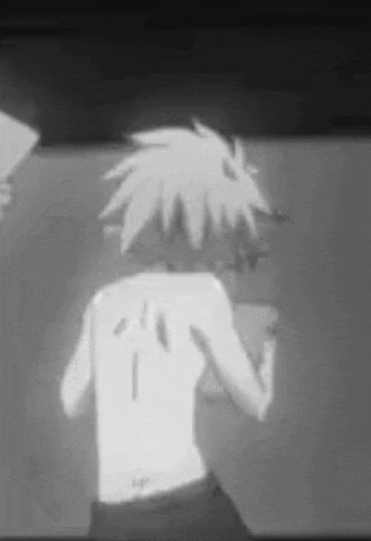 a black and white photo of a person with a tattoo on their back standing in front of a wall .