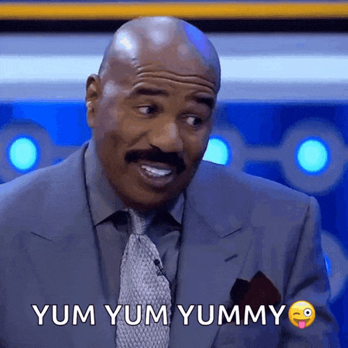 a man in a suit and tie is making a funny face and says yum yum yummy