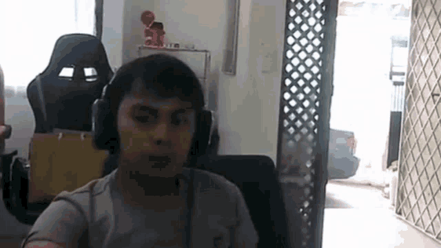 a man wearing headphones is sitting in a chair in front of a window .