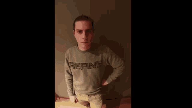 a man is wearing a grey sweater that says refine