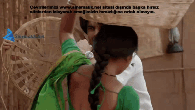 a man carrying a basket over a woman 's head with the website sinematik.net in the lower right corner